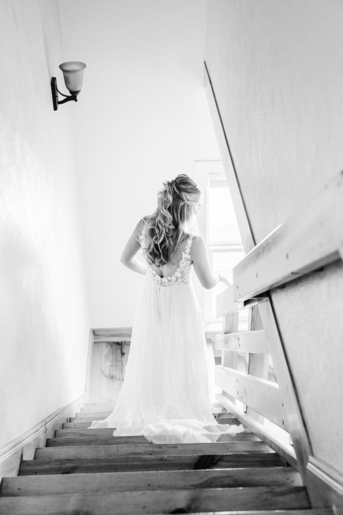 Bride walks down the stairs to join her bridal party. 